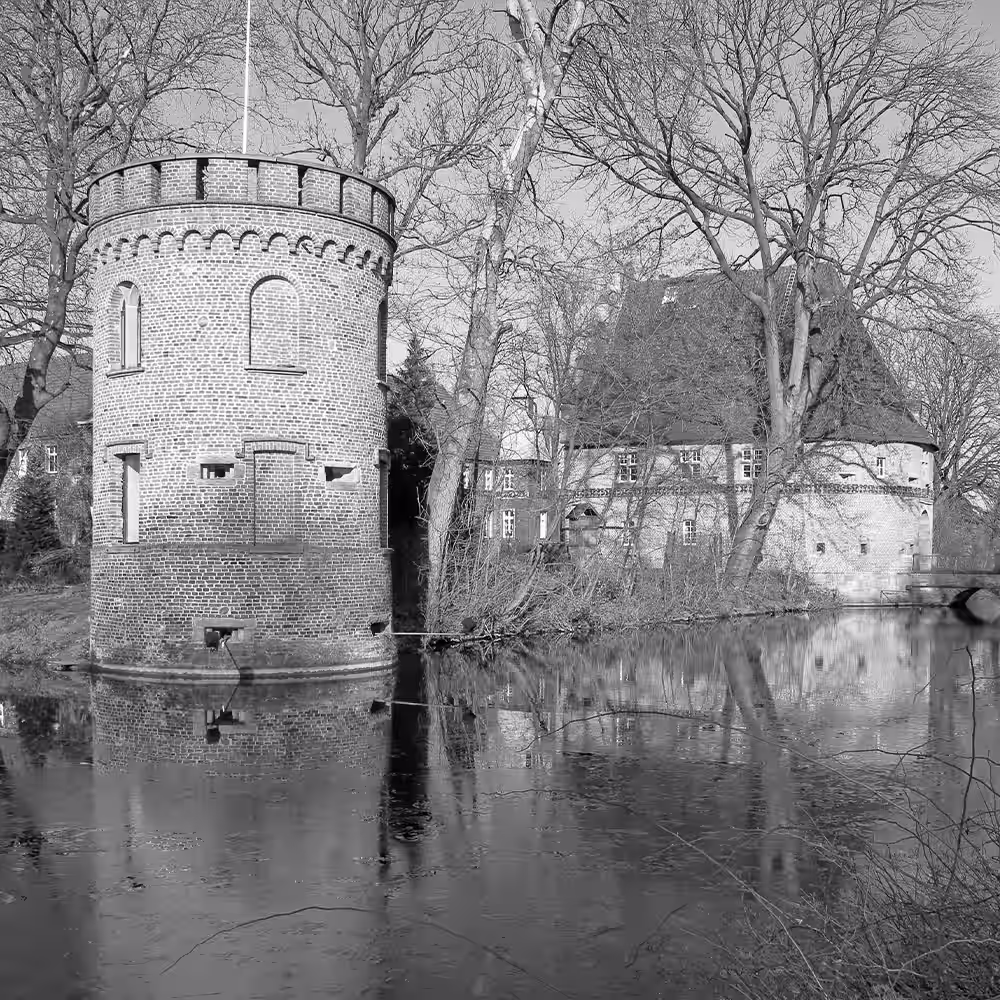Ein schwarz weiß Foto von dem Wasserschloss in Castrop-Rauxel.