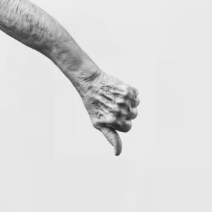 Ein schwarz weiß Foto eines männlichen Arm mit einem Daumen nach unten.